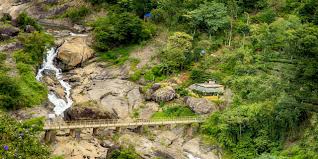 Monsoon view of Attukad Waterfalls surrounded by misty forests
